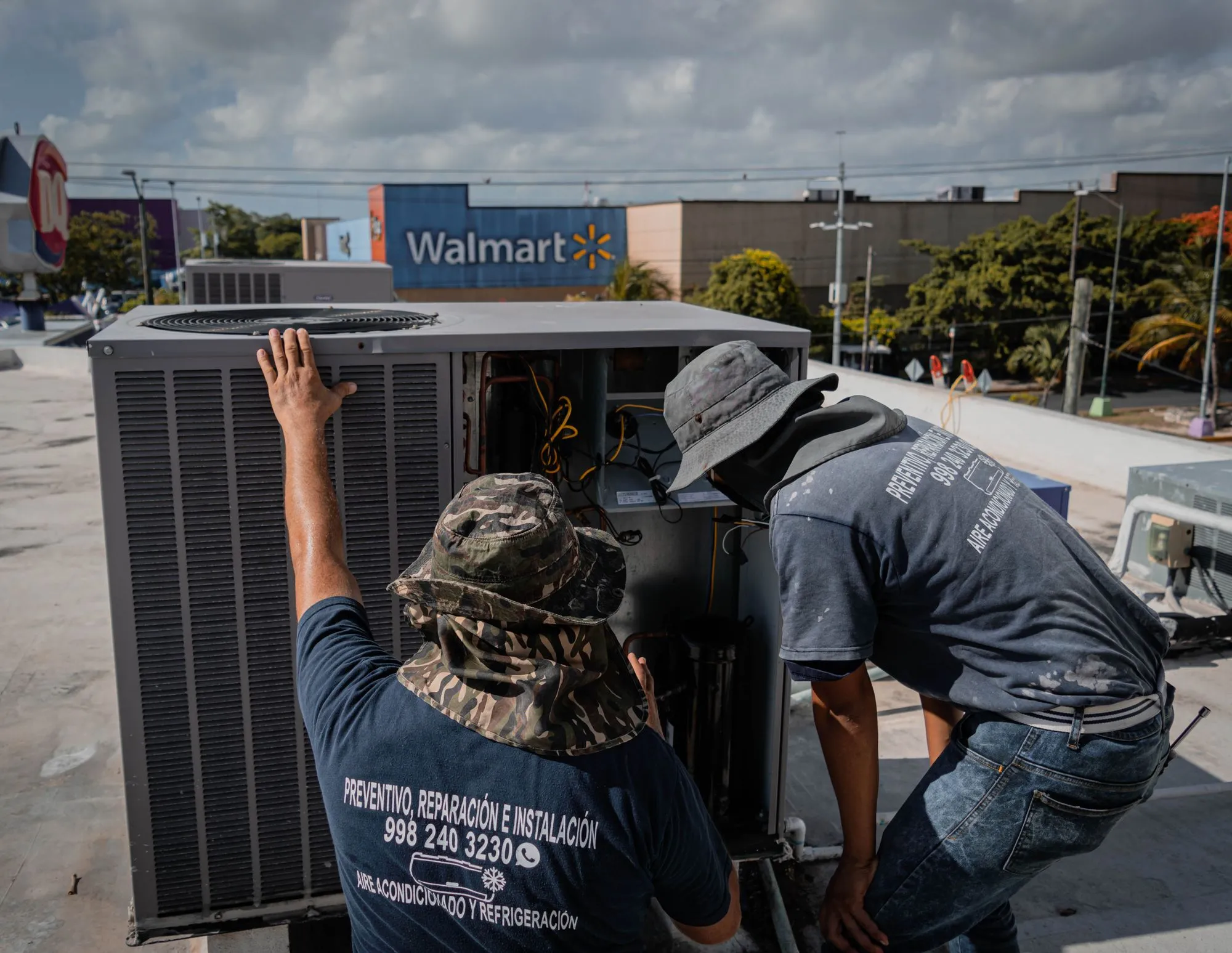 Commercial HVAC technicians servicing a rooftop package unit on a Dallas building